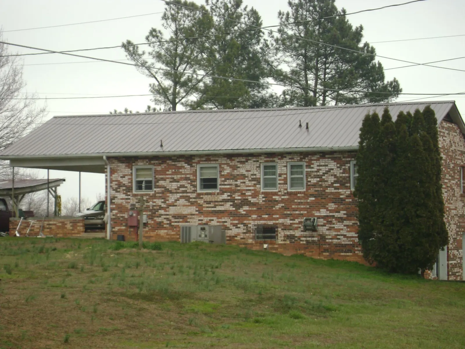 Gray metal roof on a brick split level home with a carport in Signal Mountain