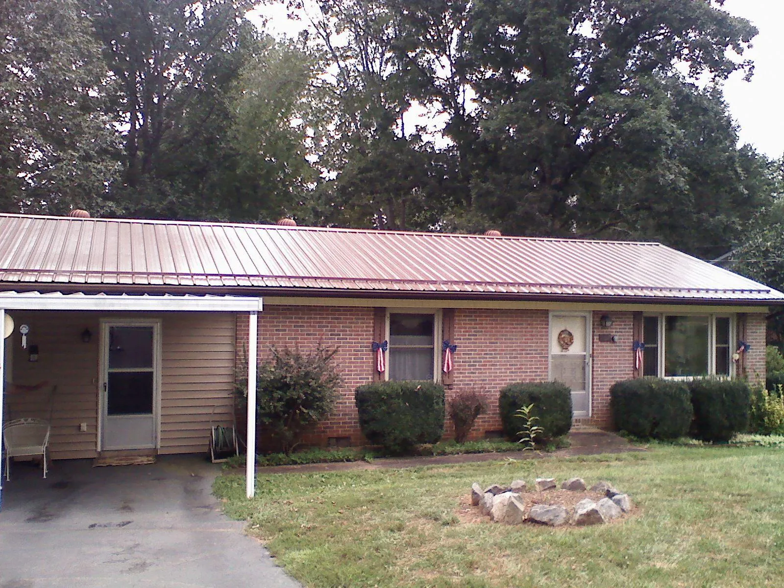 Bronze metal roof and carport on a brick ranch home — Roof Repair work by our crew in Signal Mountain